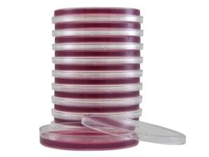 Stack of red and white petri dishes with lids.